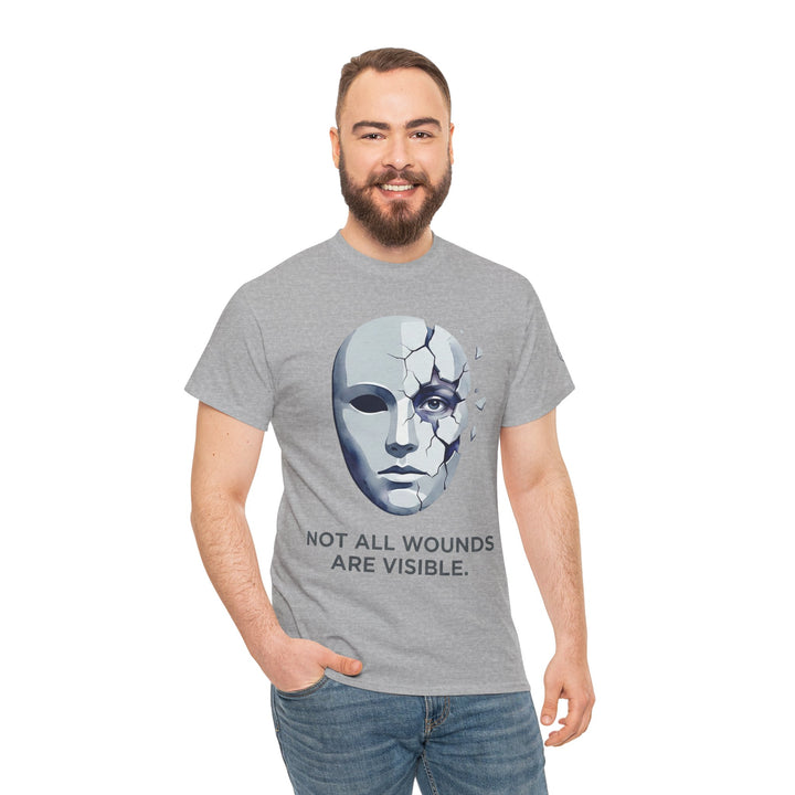 Gray t-shirt with "Not All Wounds Are Visible" and a cracked mask design, by Veteran owned, worn with jeans.