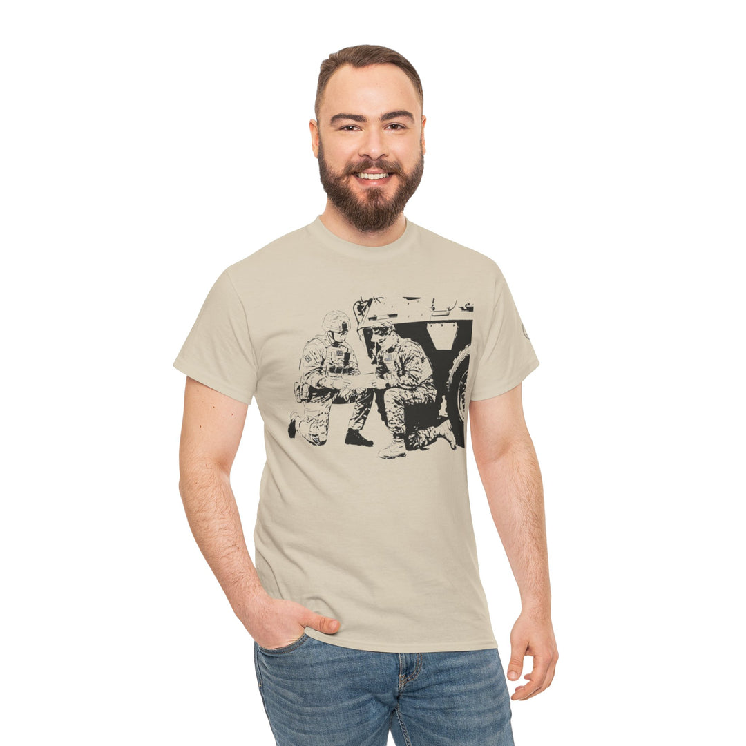 Tan t-shirt by S&amp;W Gallus, featuring a black graphic print of soldiers, worn with blue jeans.
