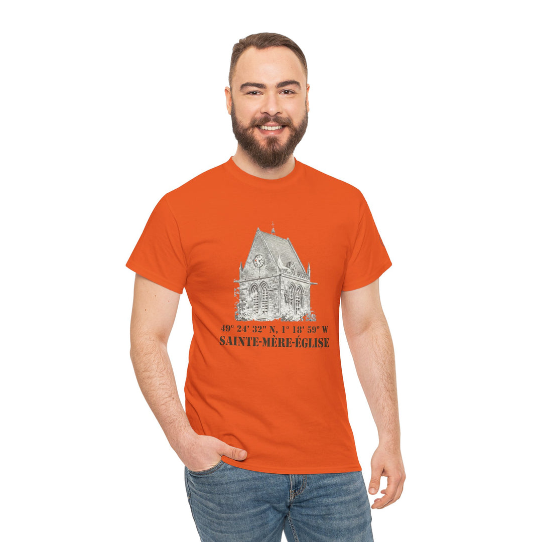 Orange t-shirt by Veteran owned, featuring a Sainte-Mère-Église church graphic and coordinates, worn with blue jeans.