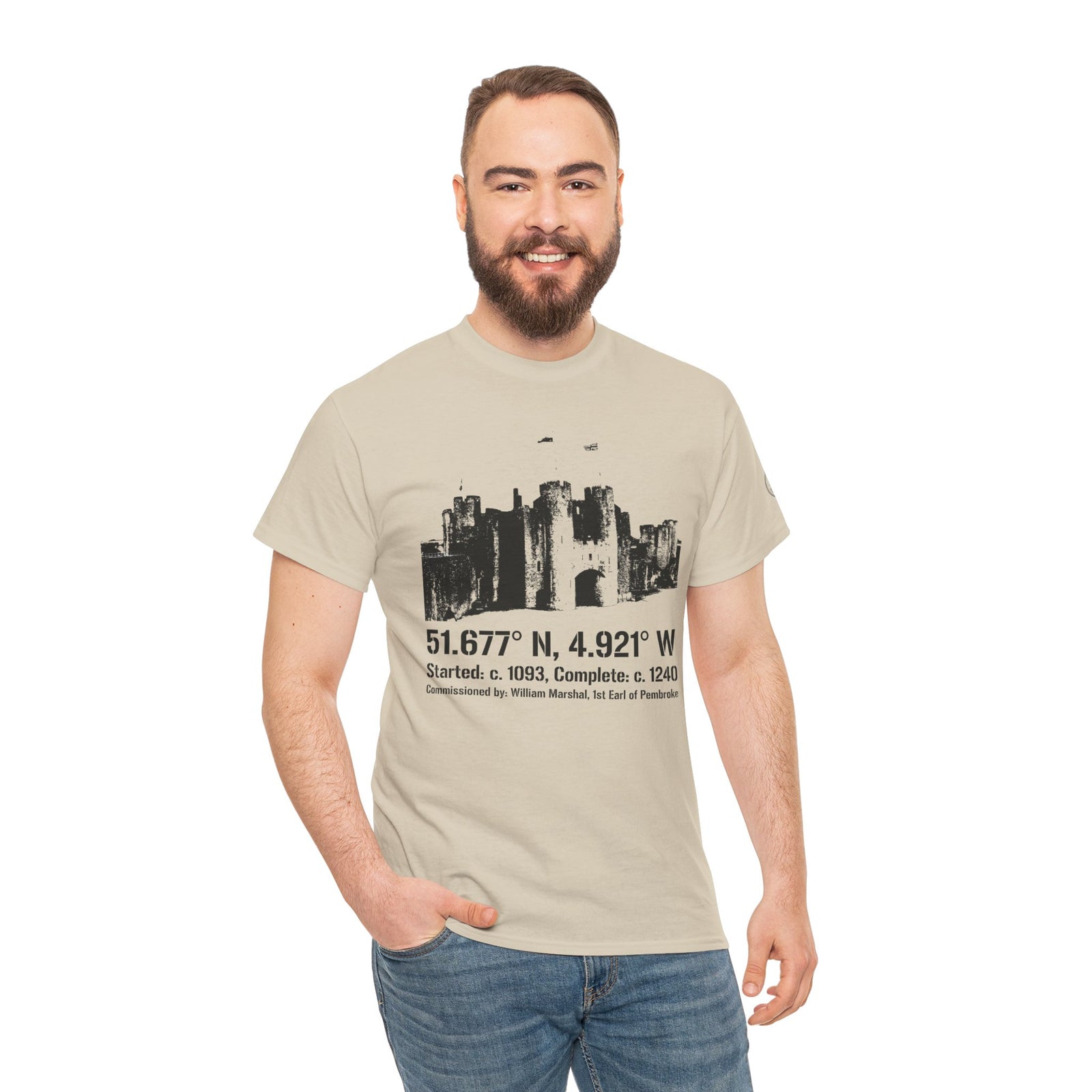 Beige Pembroke Castle T-shirt by S&W Gallus with a black castle graphic and printed coordinates, worn with jeans.