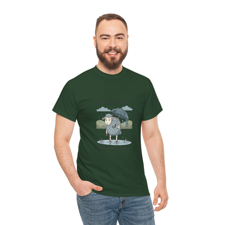 Green "Sheep in Wales" T-shirt by S&amp;W Gallus, featuring a cartoon sheep with an umbrella in the rain, worn with blue jeans.