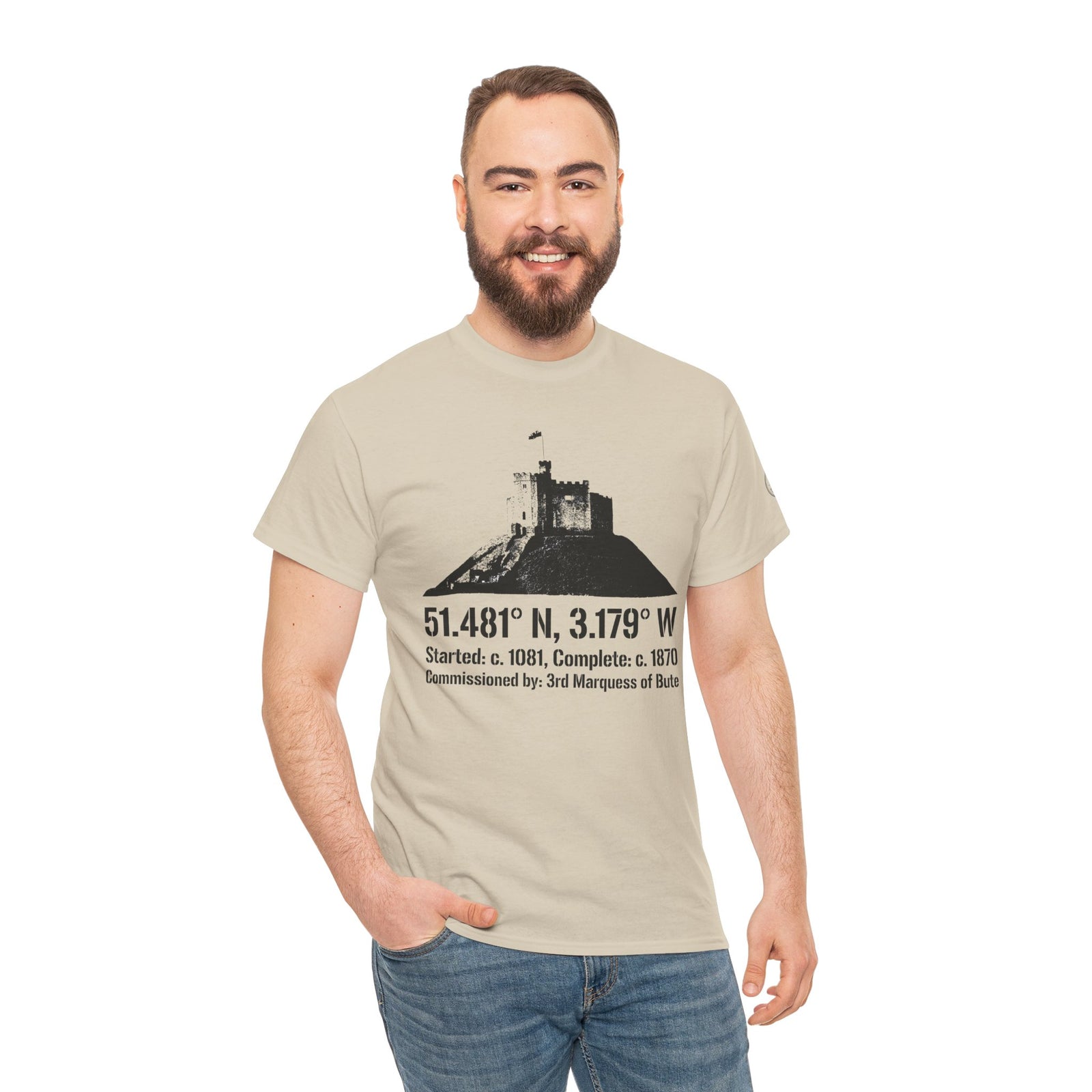 Sand-colored t-shirt by S&W Gallus featuring a castle graphic with coordinates and historical information, worn with jeans.