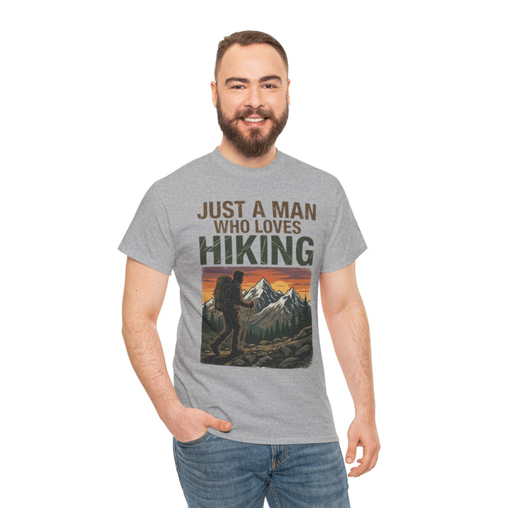 Gray "Just a Man Who Loves Hiking" T-shirt, veteran owned, featuring a retro mountain scene and worn with jeans.