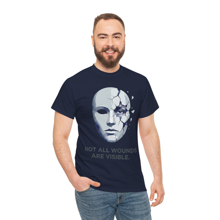 Navy t-shirt by Veteran owned, featuring a cracked mask graphic and the words, "Not All Wounds Are Visible," worn with jeans.