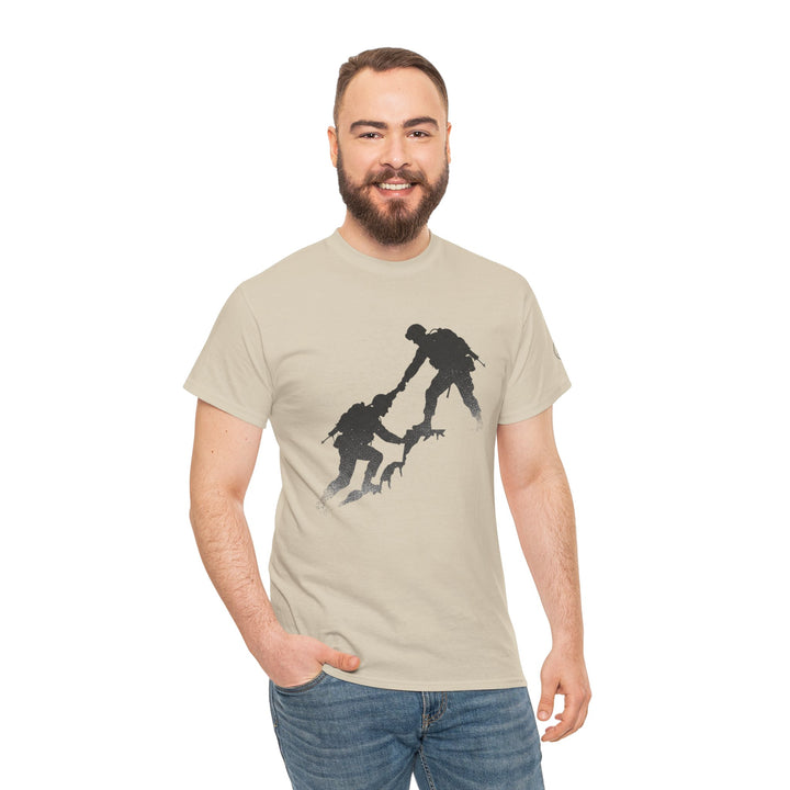 Beige t-shirt with a graphic by S&amp;W Gallus featuring two people climbing a mountain, worn with blue jeans.