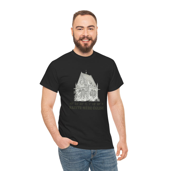 Black t-shirt with church graphic by Veteran owned, featuring Sainte-Mère-Église coordinates, worn with blue jeans.