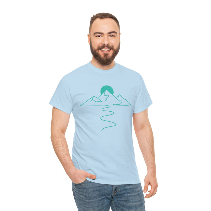 Light blue t-shirt by S&amp;W Gallus featuring a mountain and path graphic, worn with jeans by a smiling man.

