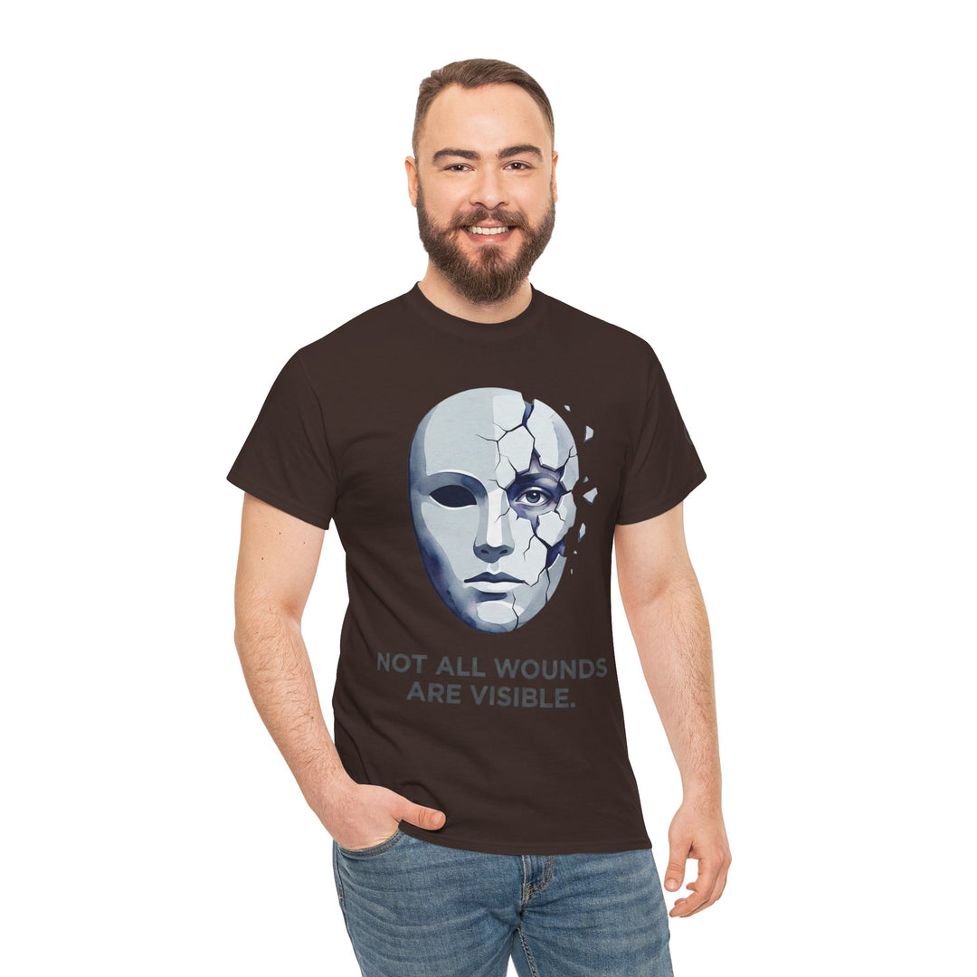 Brown t-shirt by Veteran owned, featuring a cracked mask graphic and the text "Not All Wounds Are Visible", worn with blue jeans.