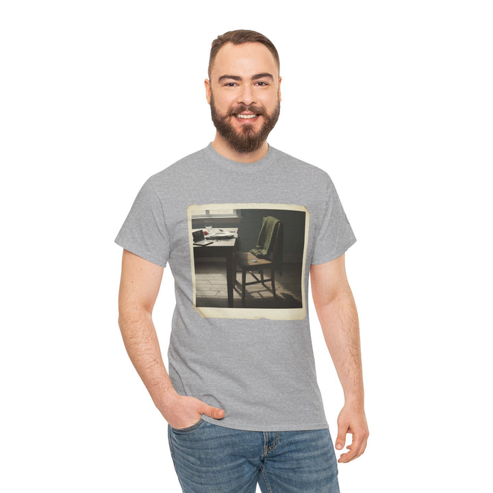 Gray t-shirt by S&amp;W Gallus featuring a faded snapshot of an empty dining table and chair, worn with blue jeans.