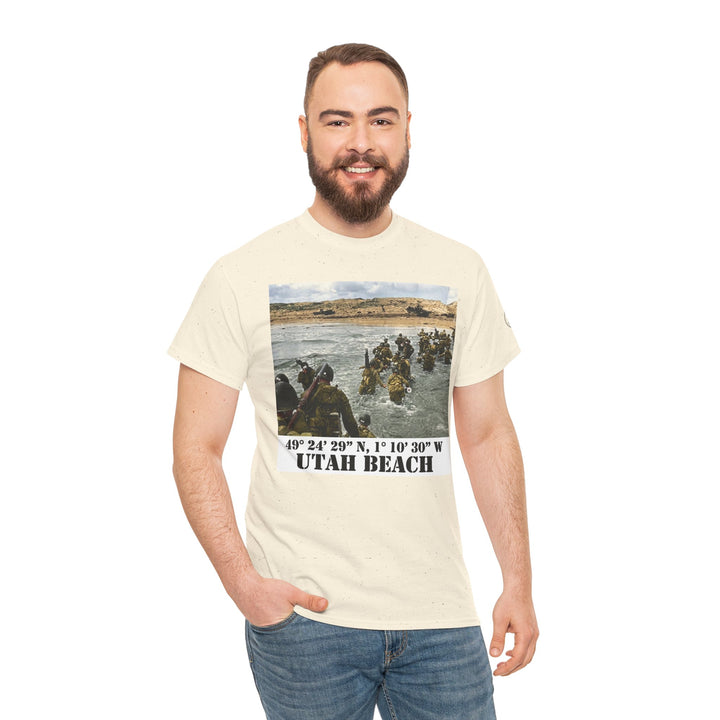 Beige graphic T-shirt by Veteran owned, featuring an image of soldiers landing at Utah Beach during D-Day. The model wears jeans.